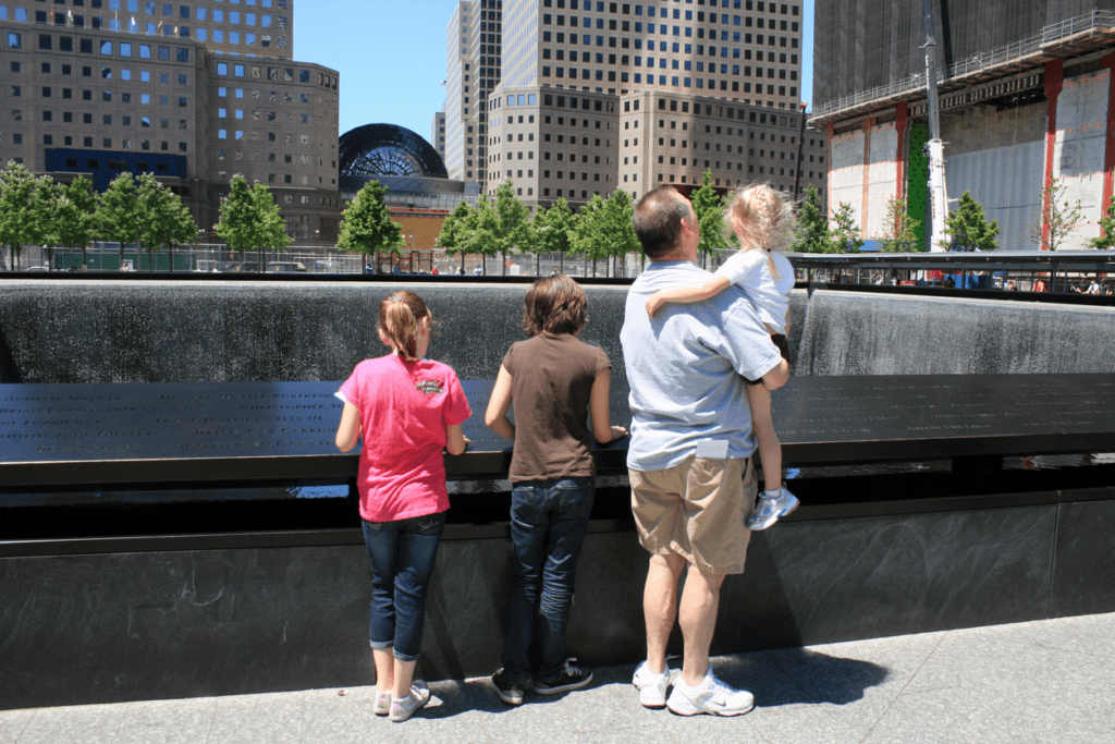 A family gathers at the North Pool at the National 9/11 Memorial Museum.