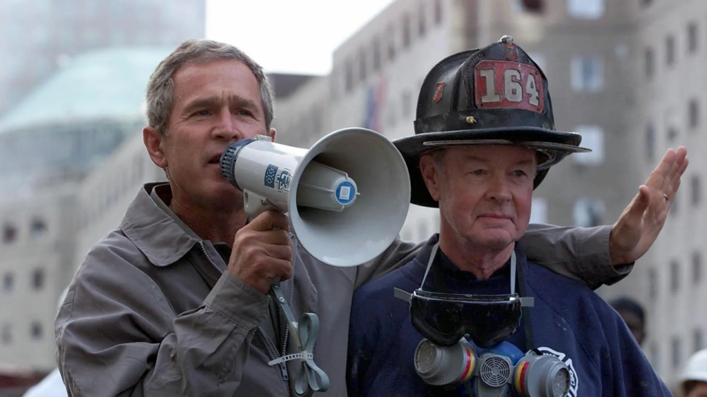 President Bush with retired Firefighter Bob Beckwith before issuing the phrase: "I can hear you! The rest of the world hears you," replied Bush. "And the people who knocked these buildings down will hear all of us soon."